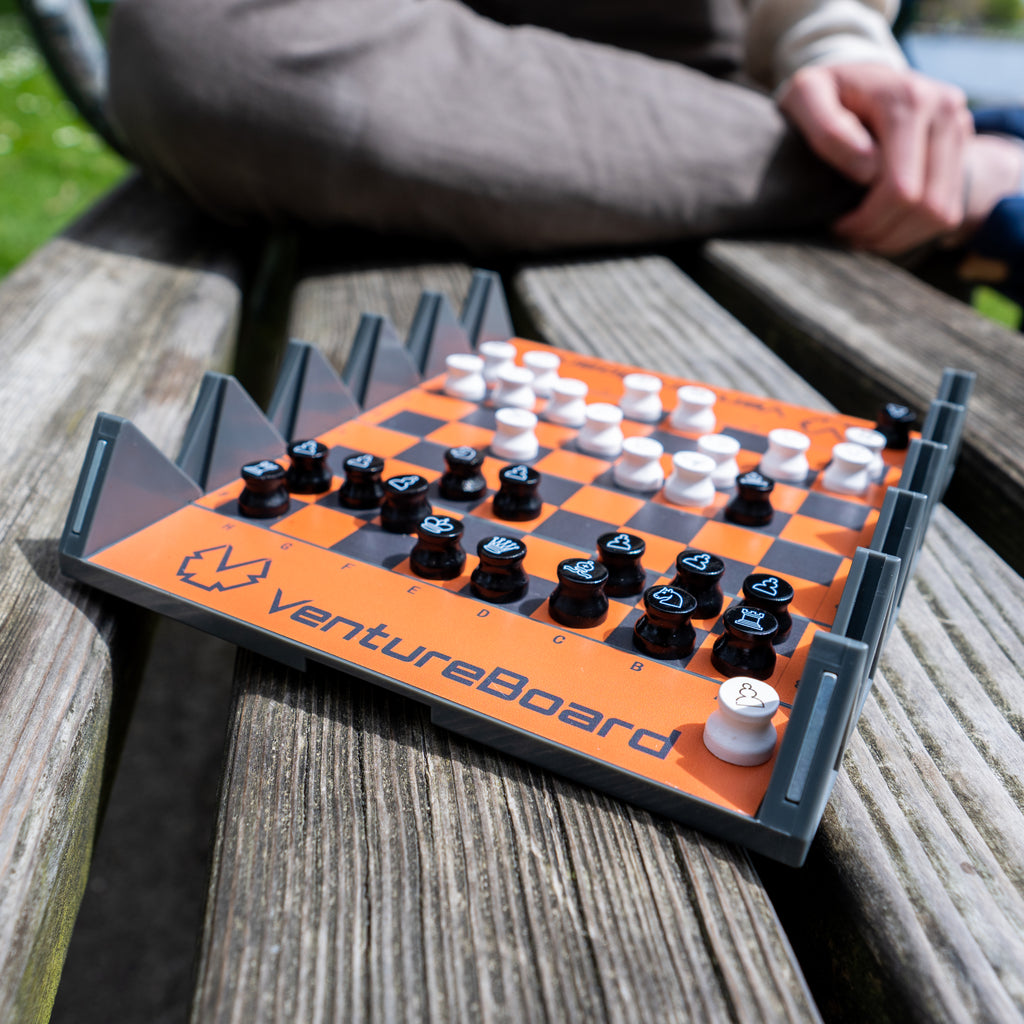 an image of a travel chess set on a bench