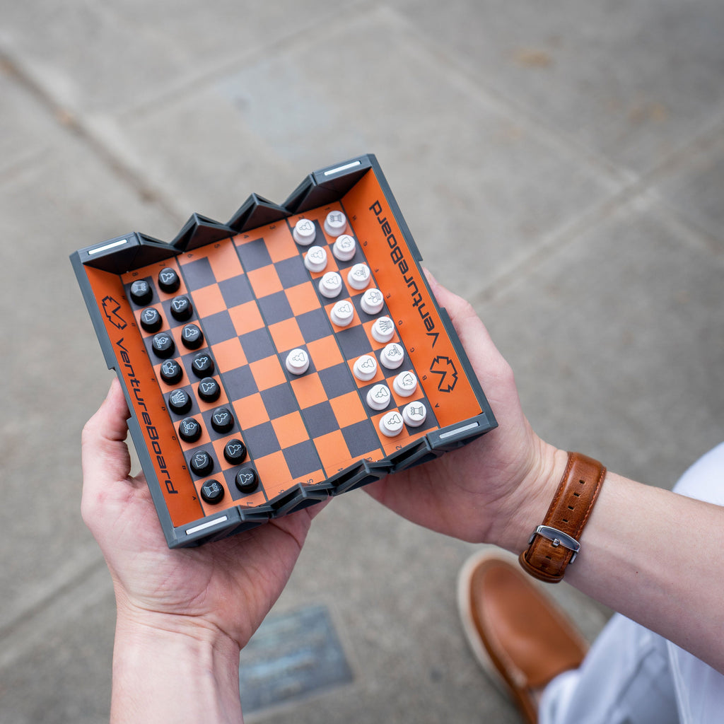 man holding travel chess set 